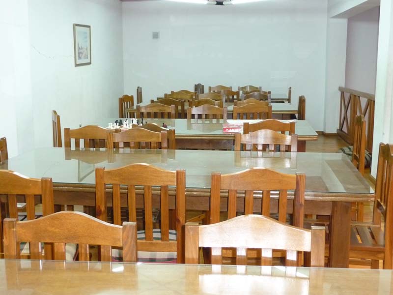 Biblioteca: sala de lectura con mesas y sillas de madera